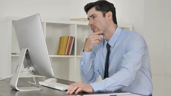 Pensive Businessman Thinking While Working on Computer