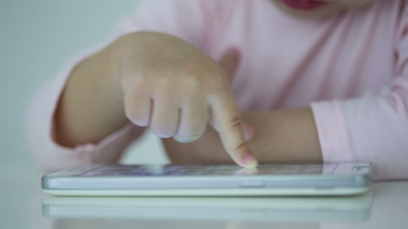 Young Child Plays On A Modern Smartphone In The Interior