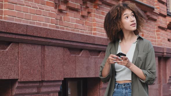Happy African American Woman Holding Phone Using Digital Assistant on Smartphone Sets Course Finds