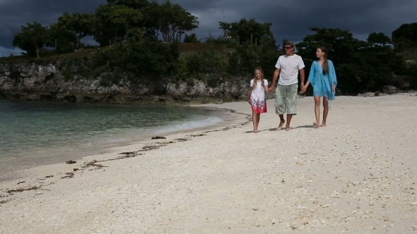 Happy Family Walking On The Beach