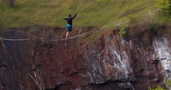 Slackliner Is Balancing and Walking on a Rope Stretched Over a Big Quarry