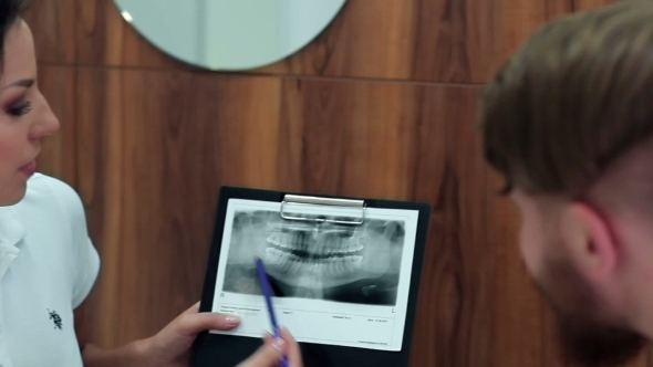Dentist Showing Patient His X-ray Image alt