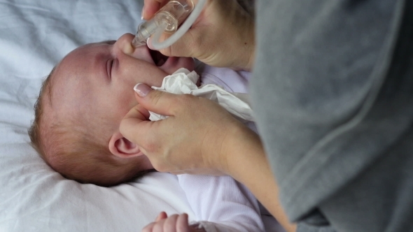 Mother Using Baby Nasal Aspirator Mucus Suction