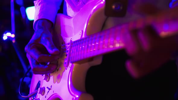 Male Guitarist Playing Electric Guitar on a Rock Concert or in the Club