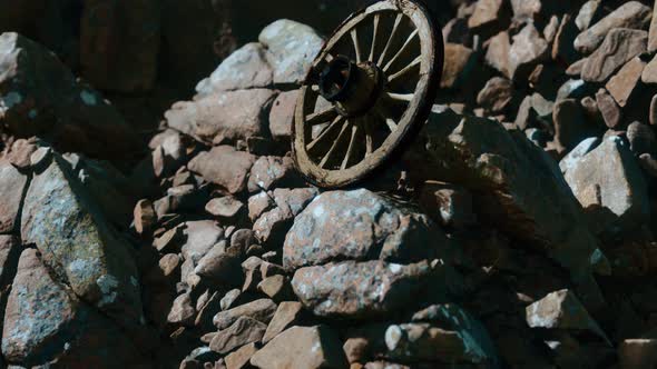Old Wooden Wheel on Rocks alt