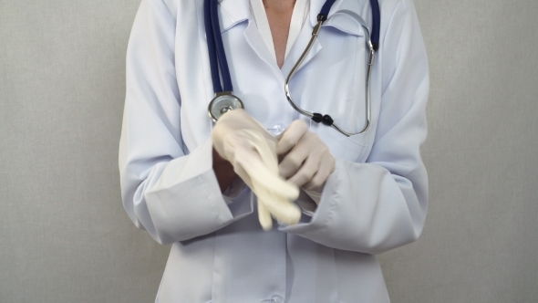 Doctor Pulling On Rubber Gloves