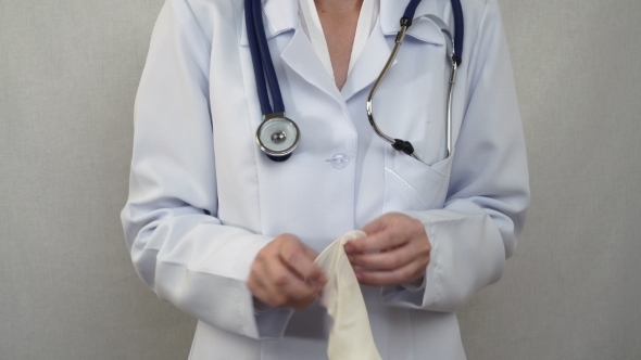 Doctor Pulling On Rubber Gloves