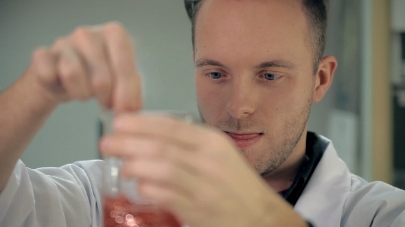 The Laboratorian Is Mixing The Ingredients In a Glass.