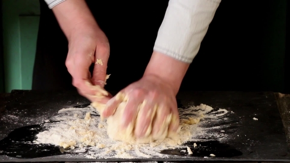 Female Hands Making Dough For Pasta Over Black Table