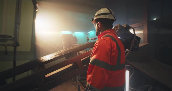 Factory Worker Standing Near Conveyor Belt with Soil