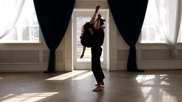 Young Dancer Man is Lifting His Female Partner on Hands Dancing and Rehearsing in Dance Hall