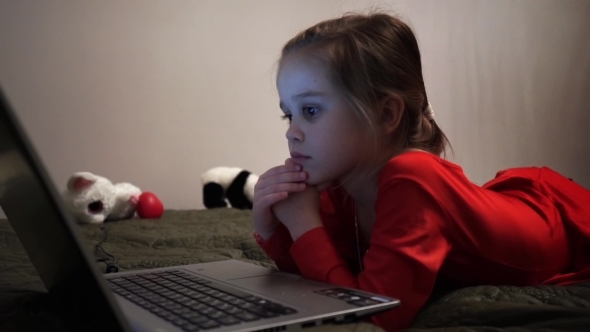 Little Girl At Night Watching Cartoons At Computer