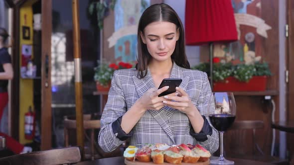 Beautiful Woman Taking Food Photos On Mobile Phone At Restaurant