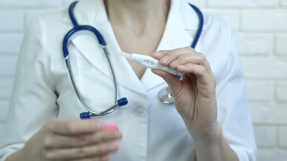 The Gynecologist Shows a Pregnancy Test