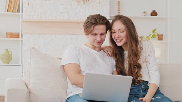 Couple Young Caucasian Family Man and Woman Make Video Call From Home Using Laptop Online App