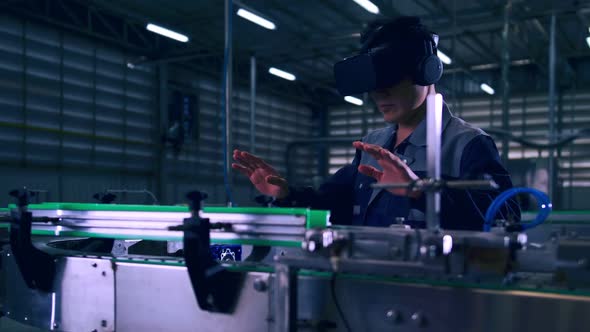 Engineer is using virtual reality glasses to inspect the factory's mechanical control system.