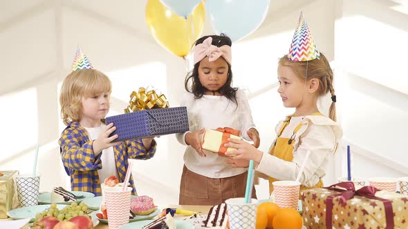 Cute African Girl Getting Gifts By Caucasian Friends