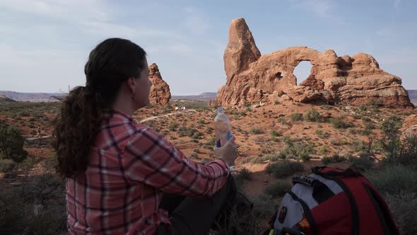 Crane Shot Of A Woman Drinking Water In Arches National Park 6