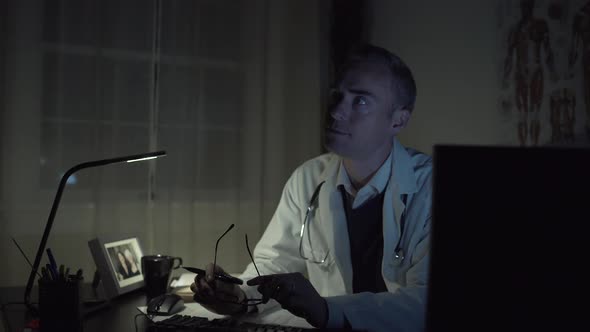 Serious Doctor Working At His Office Desk