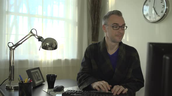 A Man In His Robe Working At His Office Desk 1 alt