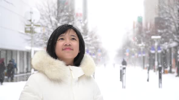 Portrait Of Beautiful Asian Girl Enjoying Snowfall