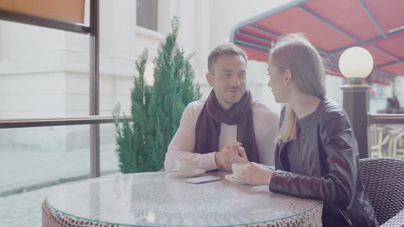 Couple In Love Drinking Coffee On Romantic Date In Cafe Outdoors