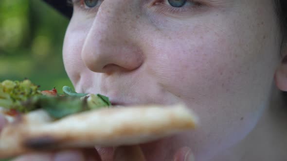 Hungry Girl Eating a Slice of Vegan Pizza