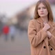 Portrait Attractive young lady in warm coat looking to camera on city street background - VideoHive Item for Sale