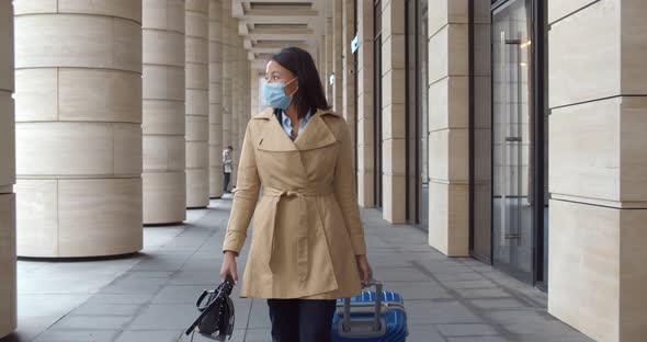 Slider Shot of Businesswoman with Suitcase Wearing Safety Mask on Business Trip