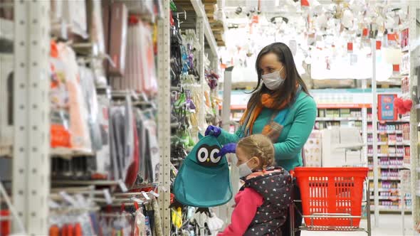 Woman and Daughter in Protective Masks Shopping