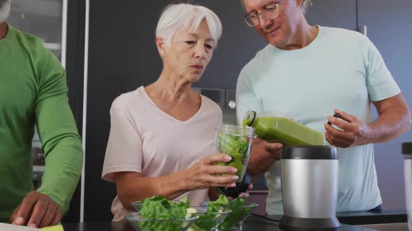 Happy senior diverse people cooking in kitchen at retirement home