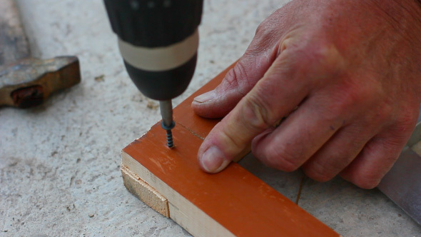 Carpenter Tightening Screw With Screwdriver In Wooden Detail