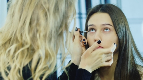 A Young Girl Apply Makeup Around The Eyes