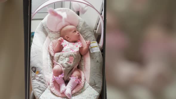  Baby Girl in Rocking Chair. Mum Making Mobile Video