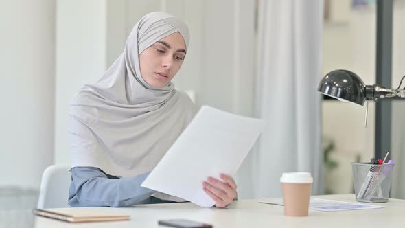 Young Arab Woman Reading Documents in Office