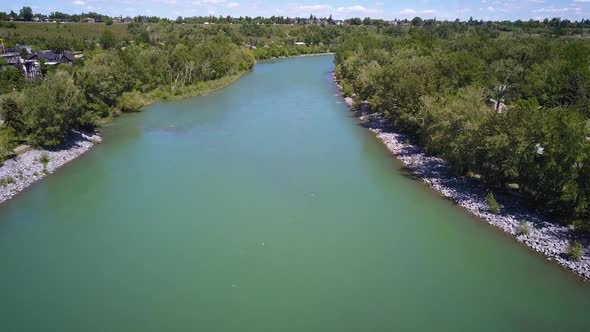 Drone flying over a beautiful river on a sunny day in the city.