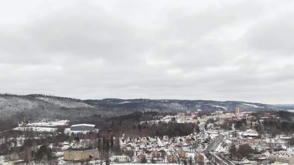 Aerial tilt down view over snowcapped Boras Arena football stadium of Sweden in winter season