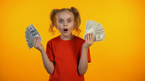 Surprised Cute Girl Holding Bunches of Dollar Cash, First Income, Banking