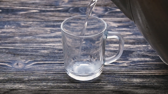 Glass of Tea With Teabag and Pouring Water in Slowmotion