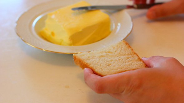Buttering A Piece Of Bread With Knife
