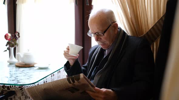 An Old Retiree Reads a Newspaper with Coffee