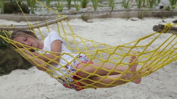 Young Girl Relaxing In a Hammock On The Sea Beach