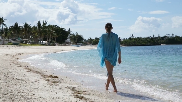 Young Girl Walks Along The Beach.