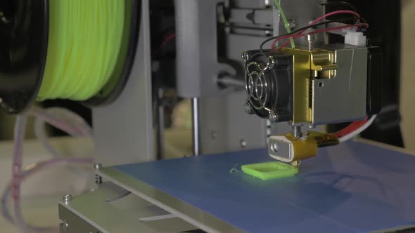 3d Printer in Process. It Makes Pieces for Equipment with Green Plastic