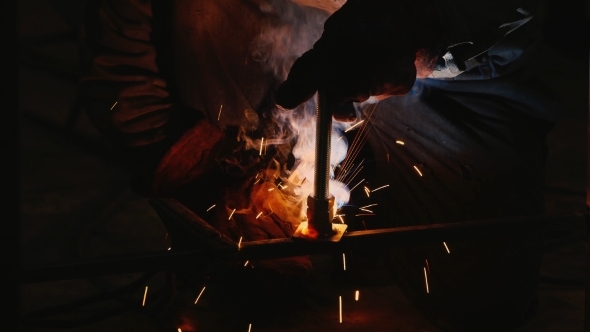 a Man Working In a Factory With Welding