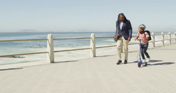 Video of happy african american father and son on scooter spending time by sea