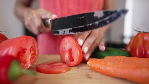 Unrecognizable Housewife Slicing Tomato in Slow Motion on Cutting Board