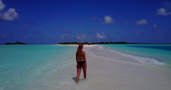 Beautiful happy ladies travelling in the sun at the beach on paradise white sand and blue background