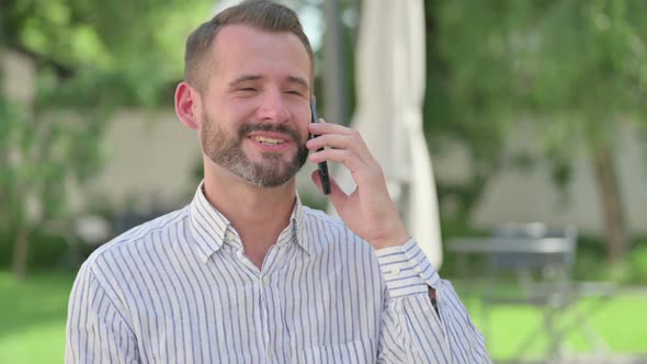 Outdoor Portrait of Middle Aged Man Talking on Smartphone