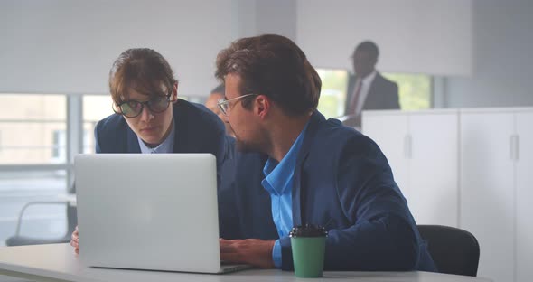 Office Employees Working on Laptop Together